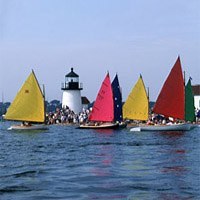 Nantucket sail boat race with lighthouse in background.